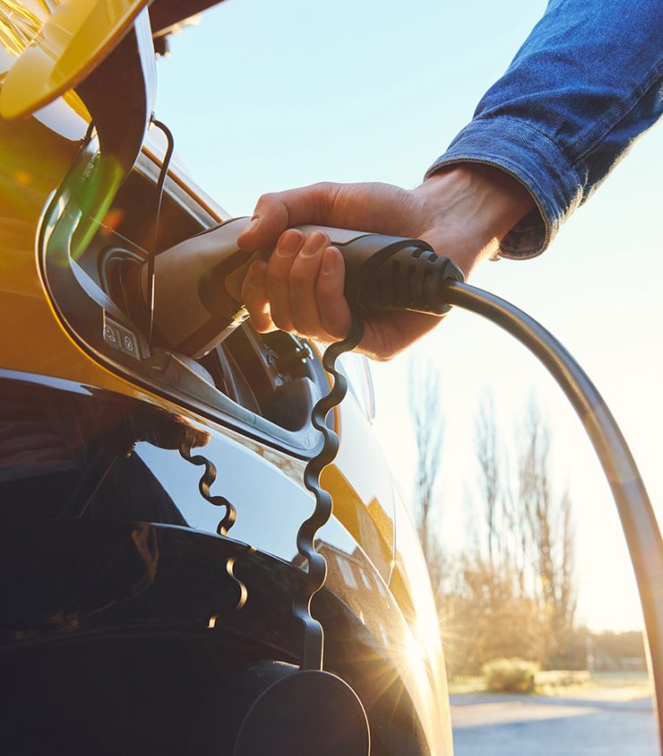 A man charging an electric vehicle