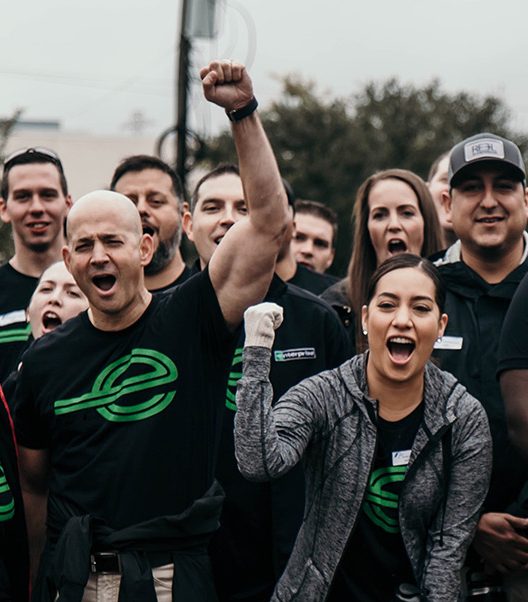  Several excited team members in black Enterprise shirts pumping their fists
