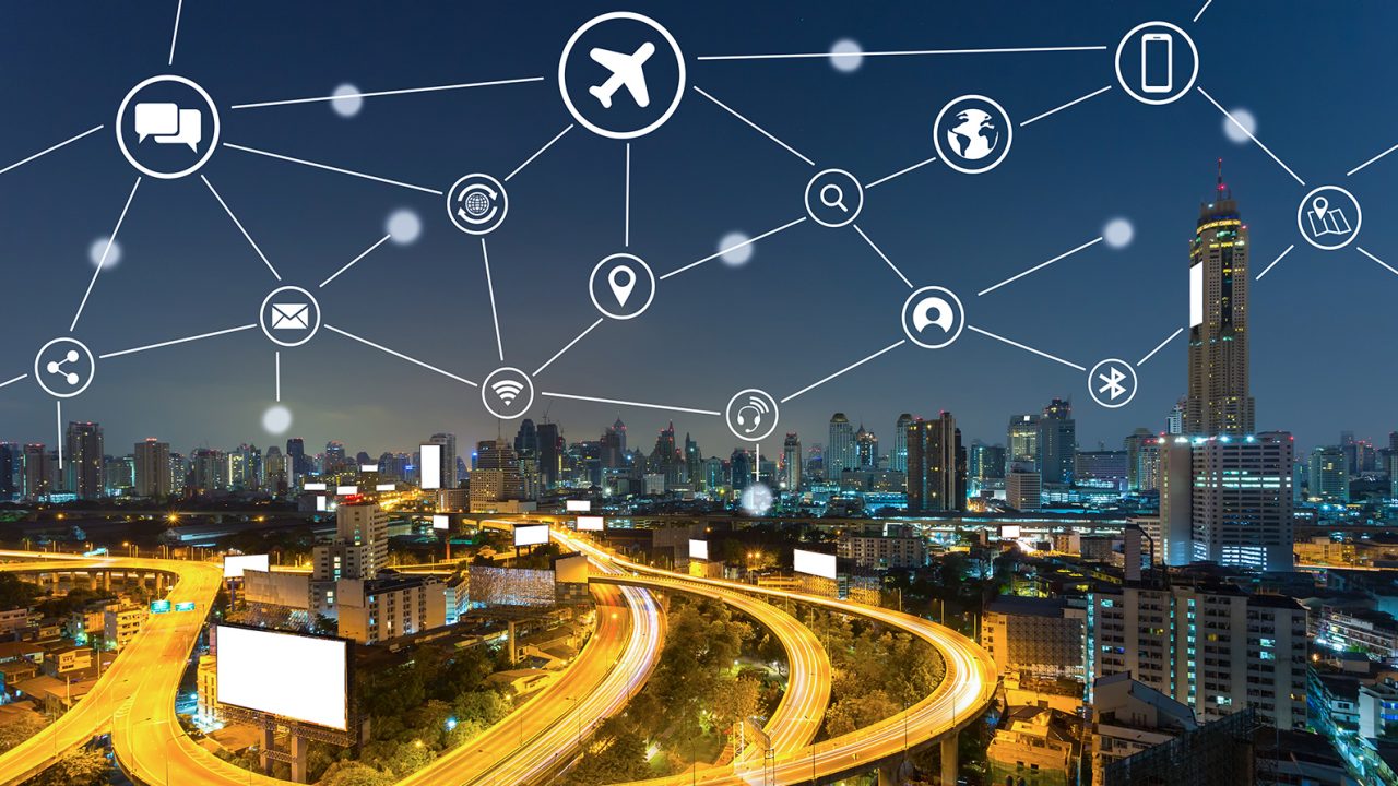 A picture of a downtown skyline at night with several innovation icons on the graphic