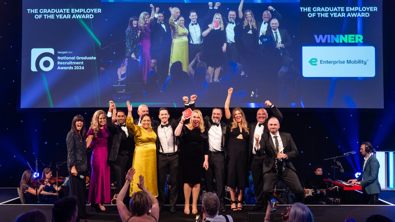 Several individuals from Enterprise Mobility, dressed in formal attire, receive the award on a stage.